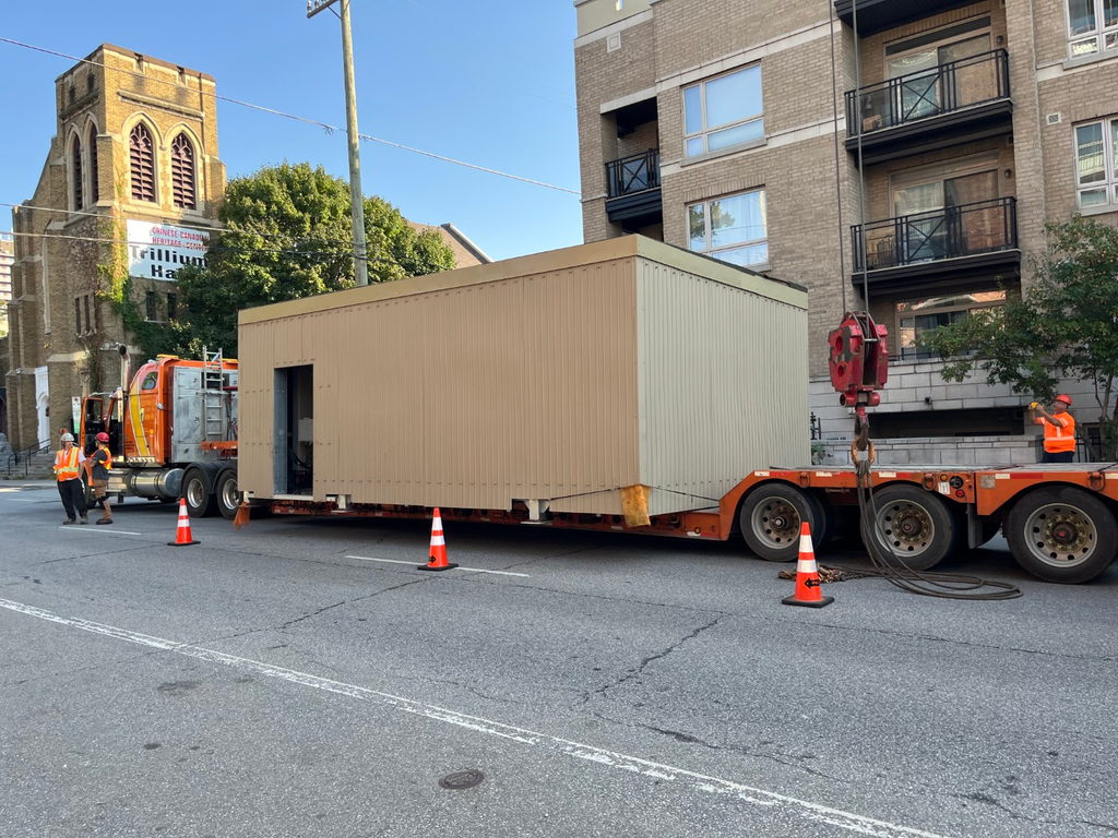 L'appentis préfabriqué sur une remorque, au pied de l'immeuble, avant le levage