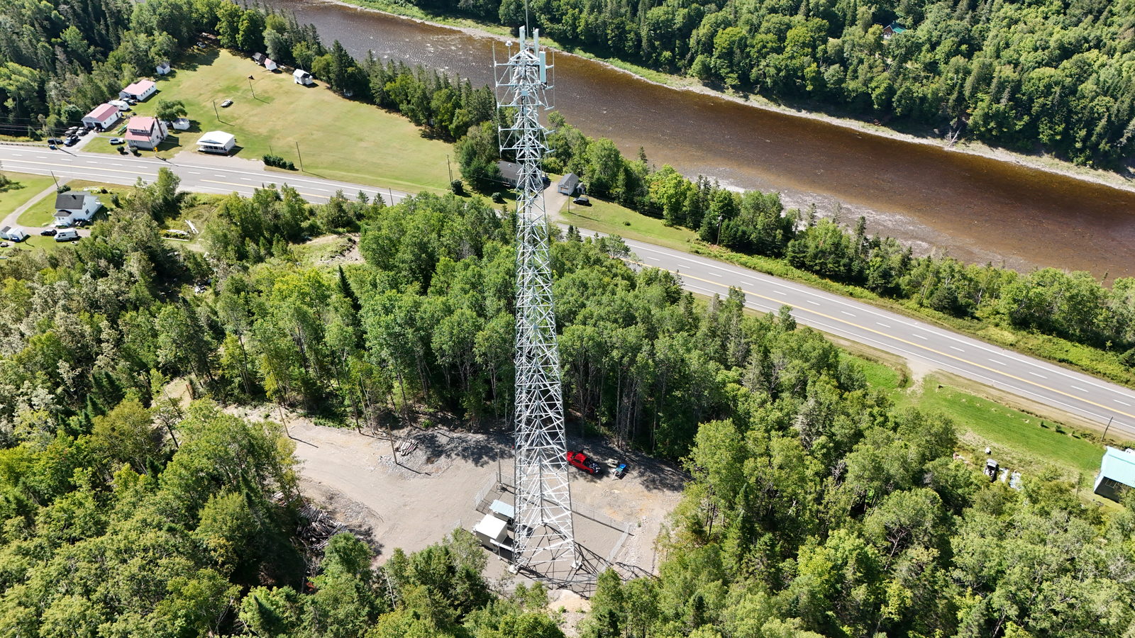 Pylône de télécommunications au bord d'une rivière, vu du ciel