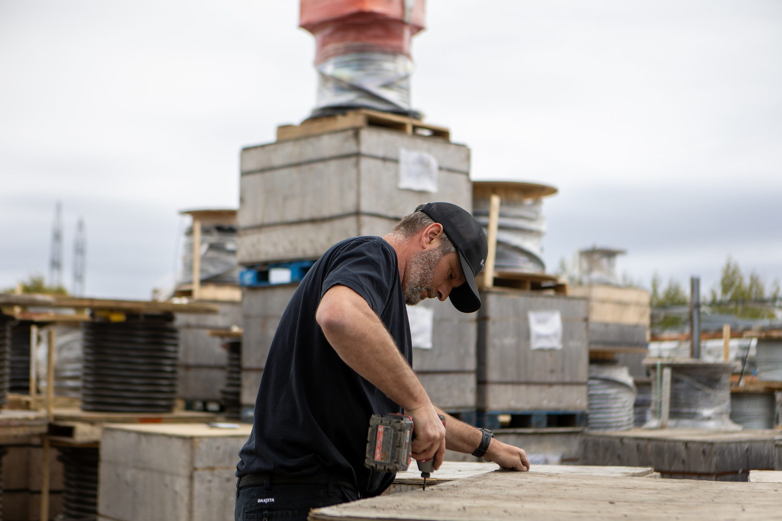 Travailleur assemblant un coffrage de béton sur un site de télécommunications